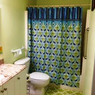 A colorful bathroom with a patterned shower curtain and matching decor.
