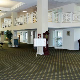 Spacious hotel lobby with carpeted floor and elegant furnishings.