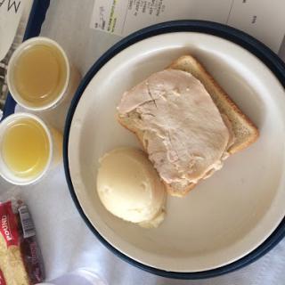 A simple meal featuring toast with turkey, mashed potatoes, and two cups of beverage.