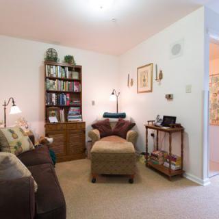 A cozy living room with a sofa, armchair, and bookshelf.