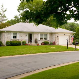A suburban house with a well-maintained lawn and driveway.