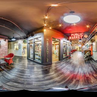 A vibrant public market featuring various food stalls and a modern interior design.