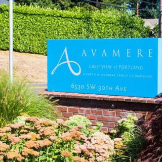 A blue sign for Avamere surrounded by landscaping.