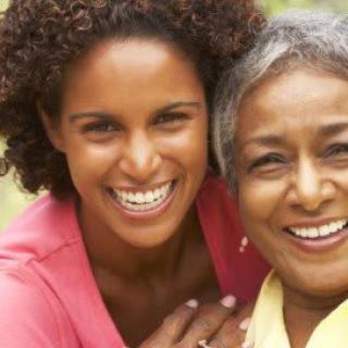 Two women smiling together outdoors.