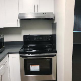 A modern kitchen with a stainless steel stove and range hood.