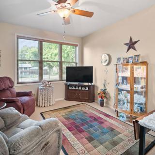 A cozy living room featuring comfortable armchairs, a TV, and decorative accents.