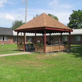 A cozy gazebo surrounded by lush green grass, perfect for relaxation.