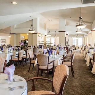 An elegant restaurant dining room with neatly arranged tables and chairs, ready for guests.
