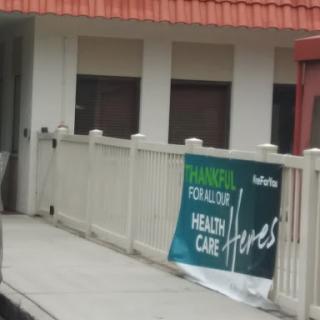 A banner promoting health care services displayed outside a building.