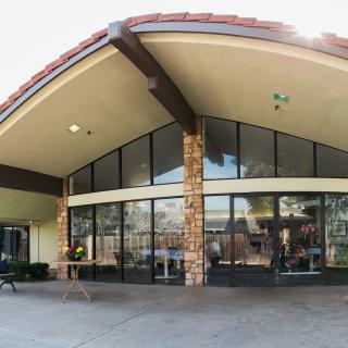 A modern commercial building with large glass windows and stone accents at the entrance.