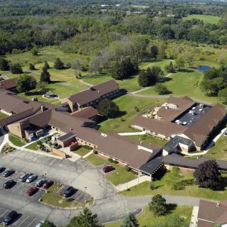 Aerial view of a large building complex surrounded by greenery.