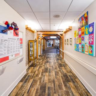 A vibrant hallway adorned with colorful artwork and wooden flooring.
