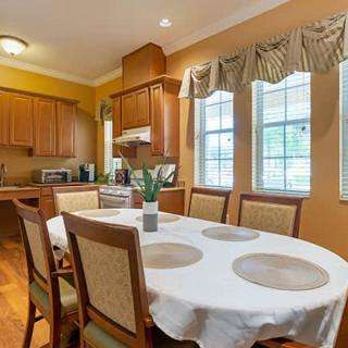 A cozy kitchen and dining area with wooden cabinets and a table set for four.