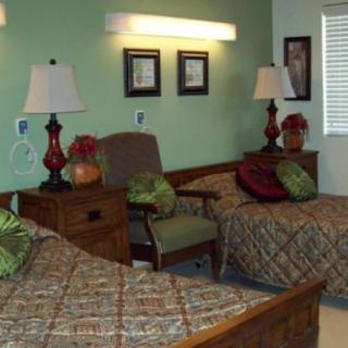 A cozy bedroom with two beds, decorative pillows, and warm lighting.