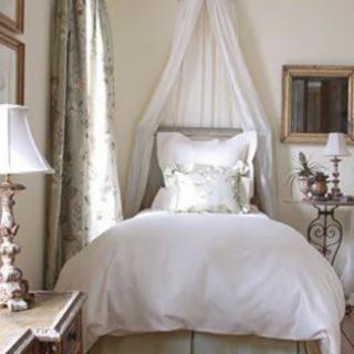 A cozy and elegantly decorated bedroom with a canopy bed and stylish lamps.