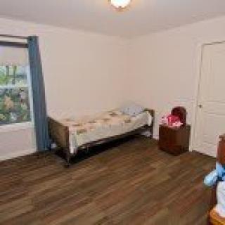 A minimalist bedroom with a single bed and wooden flooring.