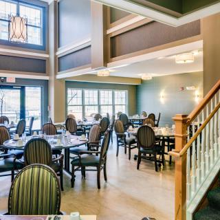 A spacious and elegantly designed restaurant interior with neatly arranged tables and chairs.
