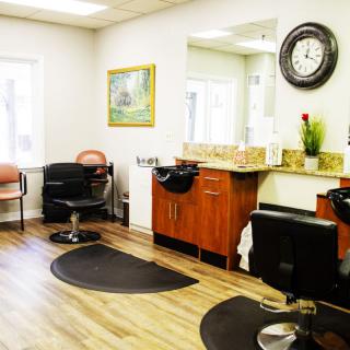 A modern hair salon with styling chairs and mirrors, featuring stylish decor.