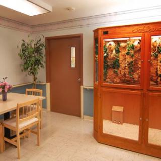 A waiting room with a table, chairs, and an aquarium.