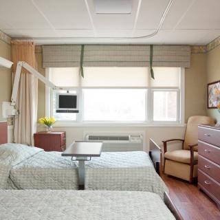 A hospital room with two beds and medical equipment.
