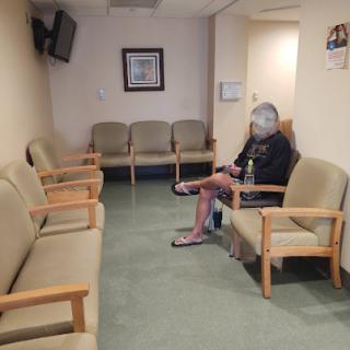 A quiet waiting room with a single patient seated.