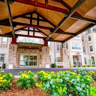 A building entrance with colorful flowers and well-maintained landscaping.