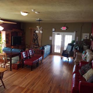 A cozy living room featuring wooden flooring, comfortable seating, and plenty of natural light.