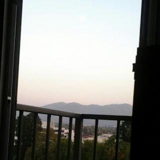 A serene view from the balcony, showcasing distant mountains and a peaceful sky.