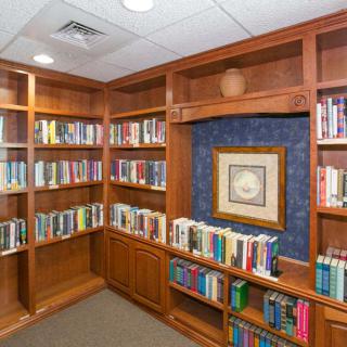 A cozy corner of a library featuring wooden bookshelves filled with books.
