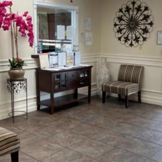 A welcoming waiting room with chairs, a decorative table, and vibrant flowers.