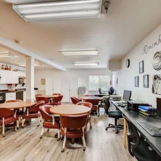 A well-lit classroom equipped with desks, chairs, and computers.
