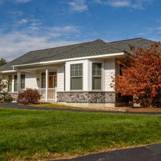 A suburban house with a well-maintained lawn and autumn foliage.
