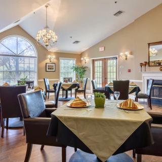 A cozy dining room with elegantly set tables and large windows.