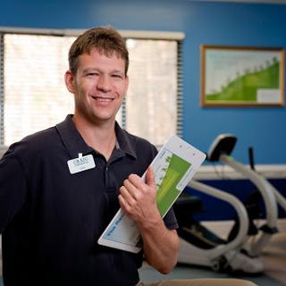 A fitness trainer in a gym, showcasing his enthusiasm for health and wellness.