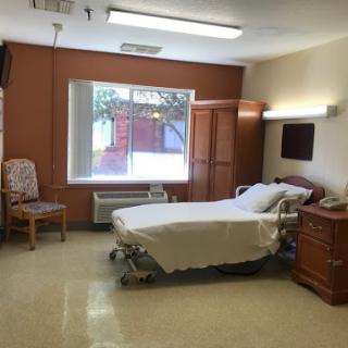 A bright and clean hospital room featuring a patient bed, window, and essential furniture.