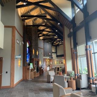A spacious and modern lobby featuring wooden beams and ample natural light.