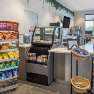 A modern cafe with a self-service snack area and display case.