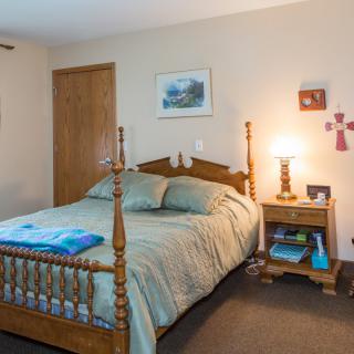 A cozy bedroom with wooden furniture and soft lighting.