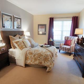 A cozy and well-decorated bedroom with a comfortable bed, elegant furnishings, and ample natural light.