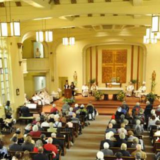 A church service with a congregation gathered in a well-lit interior.