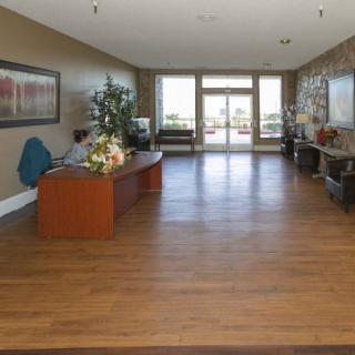 A spacious lobby with wooden flooring and modern decor.