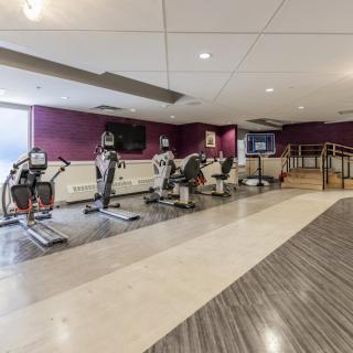 A modern gym with various exercise equipment including treadmills and workout machines.