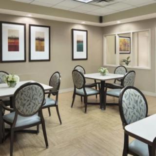 A modern dining area with neatly arranged tables and chairs, adorned with wall art.