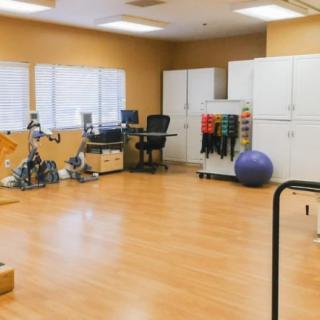 A spacious gym room with various exercise equipment, including stationary bikes and a balance ball.