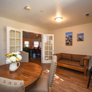 Cozy living space with a dining table and sofa, featuring wood flooring and elegant decor.