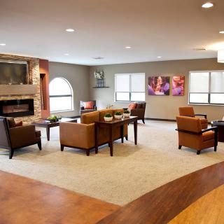 A cozy living room with comfortable chairs, a fireplace, and modern decor.