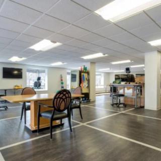 A modern open-plan office with desks and chairs.