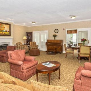 A cozy living room featuring comfortable seating, a piano, and elegant decor.