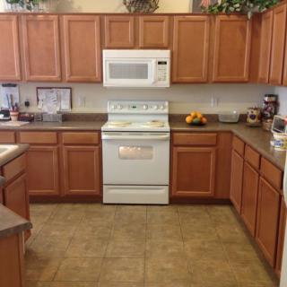 A spacious kitchen with wooden cabinets and modern appliances.