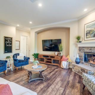 A modern living room with a comfortable seating area, wooden flooring, and a cozy fireplace.